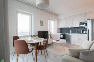 a kitchen and living room with a table and chairs at Pramea Apartments Matkatupa in Kuopio