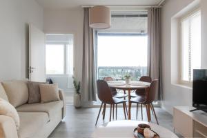 a living room with a table and chairs and a couch at Pramea Apartments Matkatupa in Kuopio