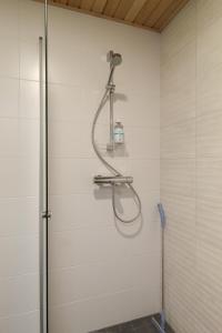 a shower with a shower head on a wall at Pramea Apartments Matkatupa in Kuopio +17 photos