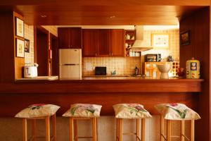 a kitchen with three stools in front of a counter at Quinta de Travanca - Casa da Eira in Baião