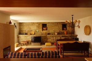 a living room with a table and a stone wall at Quinta de Travanca - Casa da Eira in Baião