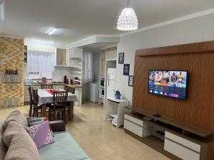 sala de estar con sofá y TV en la pared en Praia De Palmas, apartamento 2 quartos, completo próximo a praia e todo comercio, en Governador Celso Ramos
