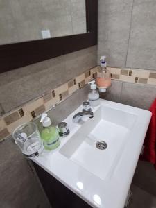 a white sink in a bathroom with a mirror at Del Sur Alquiler temporario in Sunchales