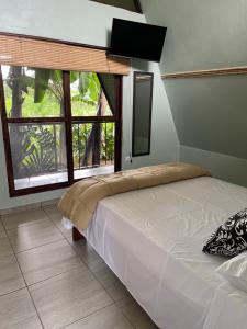 a bedroom with a bed and a large window at Las Casitas Italiana in Sabalito