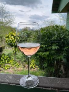 una copa de vino blanco sentada en una cornisa en Las Casitas Italiana, en Sabalito