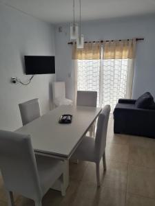 a dining table and chairs in a living room at Del Sur Alquiler temporario in Sunchales