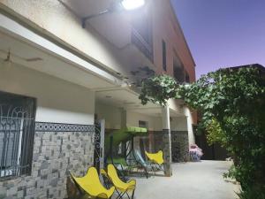 a patio with yellow chairs and a slide in a building at Bel appartement in Oujda