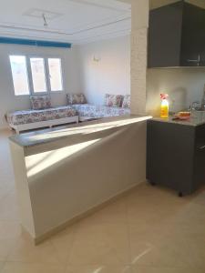 a kitchen with a counter with a counter top at Bel appartement in Oujda