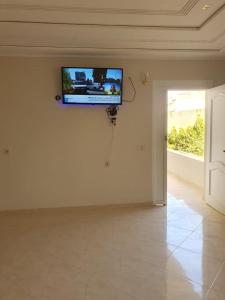 a flat screen tv on a wall in a room at Bel appartement in Oujda