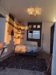 Schlafzimmer mit einem Bett, einem Fenster und einem Kronleuchter in der Unterkunft Casa Cielito Lindo - Seguridad, 10min de Centros Comerciales & Zona Esmeralda - Empresas bienvenidas in Mexiko-Stadt