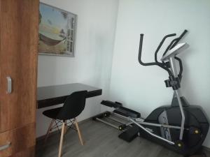 ein Raum mit einem Laufband, einem Schreibtisch und einem Stuhl in der Unterkunft Casa Cielito Lindo - Seguridad, 10min de Centros Comerciales & Zona Esmeralda - Empresas bienvenidas in Mexiko-Stadt
