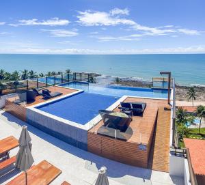 a swimming pool with a view of the ocean at FLATS ENSEADA Do SOL in Jacumã