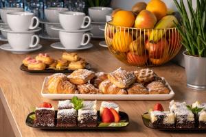 a table topped with different types of pastries and fruit at Park Inn by Radisson Vilnius Airport Hotel & Conference Centre in Vilnius