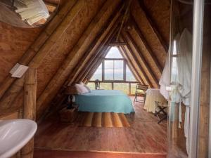a bedroom with a blue bed in a attic at Glamping brisa de guadua in Moniquirá