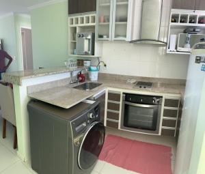 una cocina con lavadora y fregadero en MANDAI FLAT 412, en Cabo Frío