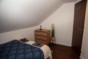 une chambre avec un lit et une commode en bois dans l'établissement July Holiday House, à Dugo Selo 9 autres photos