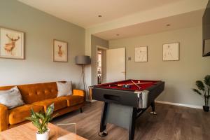 ein Wohnzimmer mit einem Sofa und einem Billardtisch in der Unterkunft Luxury Affordable Business Stay with Hot Tub and Pool Table in Enfield Lock