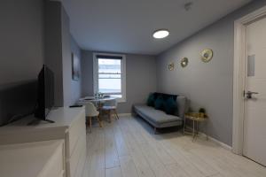 a living room with a couch and a table at Central Brighton modern one bed apartments in Brighton & Hove