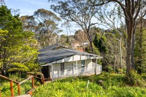 uma casa com um telhado preto na floresta em Tree Tops Katoomba em Katoomba