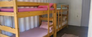 a couple of bunk beds with pink pillows on them at Casa Container na Serra da Bocaina in São José do Barreiro