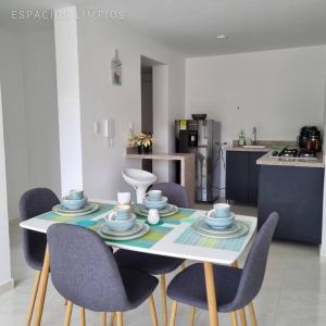 a dining room table with chairs and a kitchen at iluminado y conformable apto con excelente vista in Cúcuta