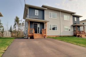 a house with a driveway in front of it at Beautiful Home in Moncton North! in Moncton