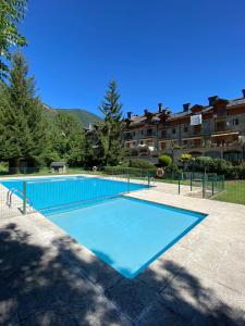 a large blue swimming pool in front of a building at El Estudio de Buenavista in Biescas