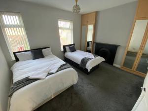 a bedroom with two beds and a fireplace at 7 bed - Spacious House - Central Manchester in Manchester