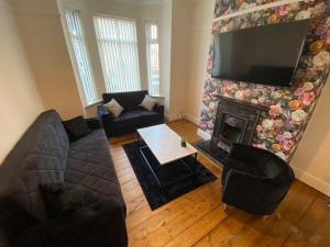 a living room with a couch and a fireplace at 7 bed - Spacious House - Central Manchester in Manchester