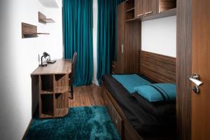 ドロベタ・トゥルヌ・セヴェリンにあるApartament CENTRAL 1のベッド、デスク、テーブルが備わる小さな客室です。