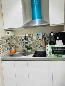 a kitchen counter with a sink and a microwave at Fantastico Estudio Cuatro Camino in Madrid