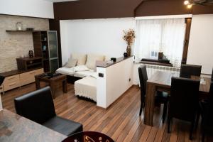ein Wohnzimmer mit einem Sofa und einem Tisch in der Unterkunft Apartament CENTRAL 1 in Drobeta-Turnu Severin
