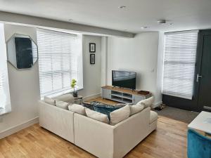a living room with a couch and a flat screen tv at Luxury Northampton Town Centre Apartment in Northampton