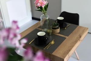 una mesa de madera con un jarrón de flores. en Luxury room with king size bed en Dordrecht