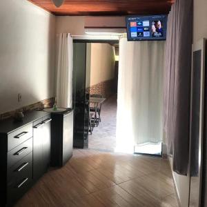 um quarto com uma cozinha com uma televisão na parede em BLUE DOOR BRASIL em Abraão