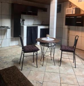 uma mesa e duas cadeiras numa cozinha em BLUE DOOR BRASIL em Abraão