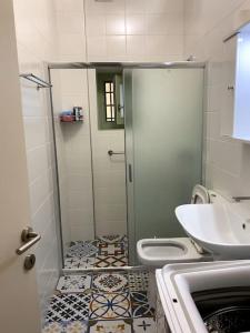 uma casa de banho com um chuveiro, um WC e um lavatório. em Ανακαινισμένο διαμέρισμα σε αρχοντικό 19ου αιώνα, κέντρο Μύρινας em Myrina