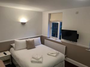 尼德姆馬基特的住宿－Limes hotel，酒店客房设有一张床铺,墙上配有电视。