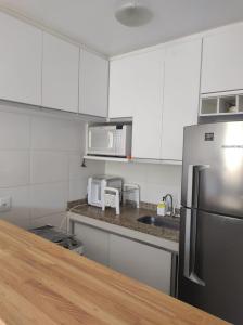 a kitchen with white cabinets and a stainless steel refrigerator at Ribeira Guest House in Angra dos Reis