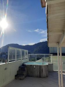 a balcony with a hot tub on top of a house at Ribeira Guest House in Angra dos Reis