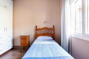 1 dormitorio con 1 cama con cabecero de madera y ventana en Miriam`s Place en Mendoza