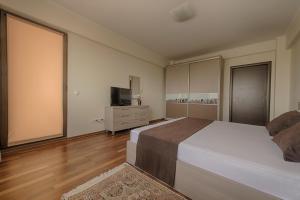 a bedroom with a large bed and a television at Samali Residence in Eforie Nord