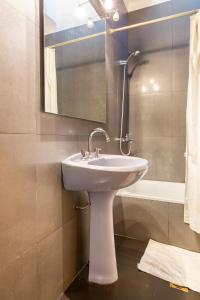 uma casa de banho com um lavatório, um espelho e uma banheira em Miriam`s Place em Mendoza