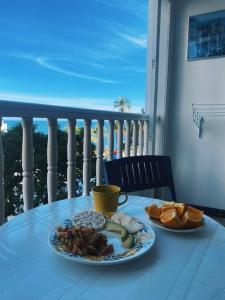 una mesa con 2 platos de comida en el balcón en Apartamento con playa privada en Santa Marta, en Santa Marta