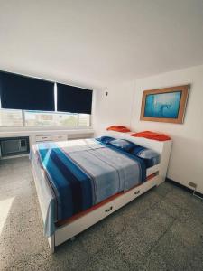 1 dormitorio con 1 cama en una habitación con ventana en Apartamento con playa privada en Santa Marta, en Santa Marta