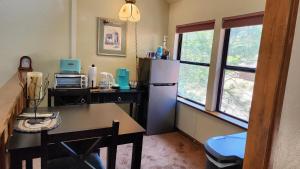 cocina con nevera, mesa y ventana en Yosemite Mountain Retreat en Oakhurst
