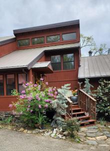 a red house with a staircase and flowers in front of it at Yosemite Mountain Retreat in Oakhurst