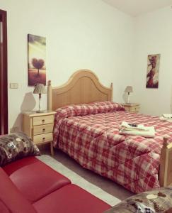 a bedroom with two beds and a nightstand and a bed sidx sidx sidx sidx at Locanda 130 in Fonni