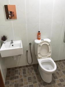 a bathroom with a toilet and a sink at Bayu Apartment Services in Kuah