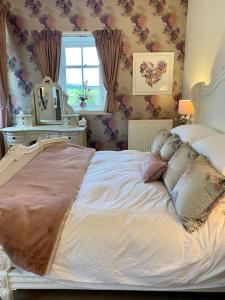 Un dormitorio con una cama con almohadas. en Luxury Scottish Manor house + jacuzzi + bbq cabin + helipad, en Maybole